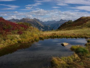 Scenic view of lake by mountains against sky