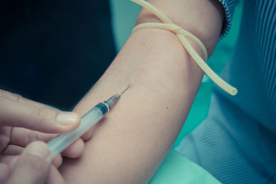 Cropped hand of doctor injecting patient