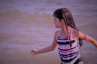 Wet little girl playing on sea shore