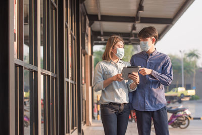 Couple wearing mask discussing while standing outdoors