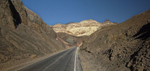 Road amidst desert against sky