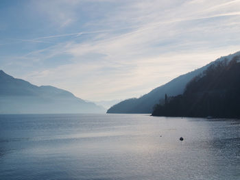 Scenic view of sea and mountains against sky