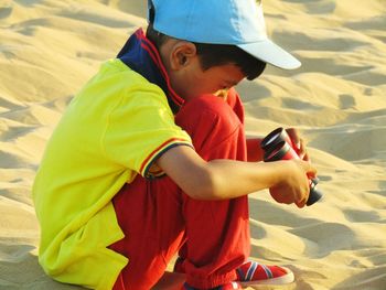 Side view of boy playing on sand at beach