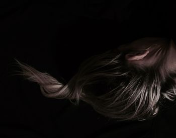 Portrait of woman against black background