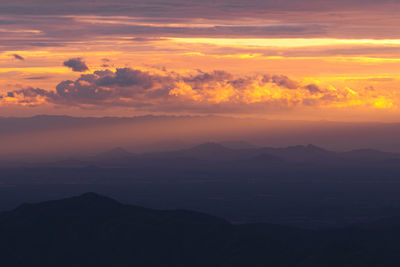 Scenic view of dramatic sky over silhouette landscape