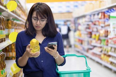 Mid adult woman looking away while standing at store