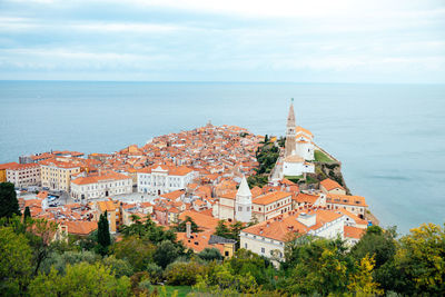 High angle view of townscape by sea against sky