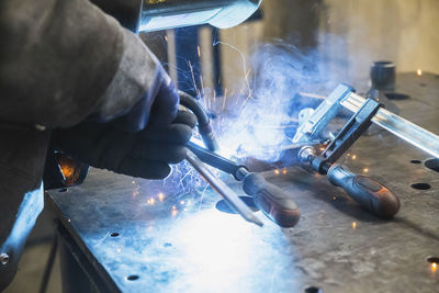 Semi-automatic welding with sparks and smoke at the factory