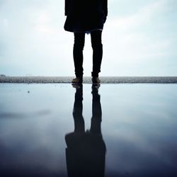 Low section of woman standing in lake