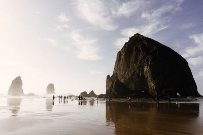 Panoramic view of rock formations by sea against sky