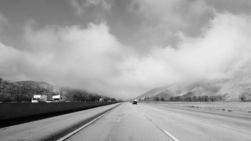 Road leading towards mountain against sky