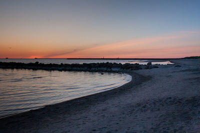 Scenic view of beach against sky during sunset