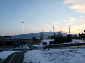 Wet street during winter against sky