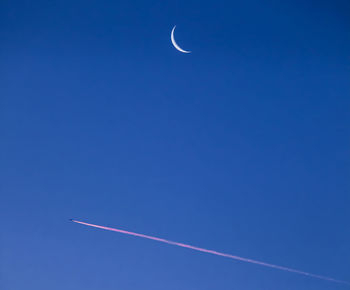 Low angle view of vapor trail against clear blue sky