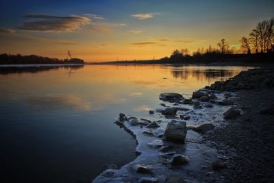 Scenic view of lake against sky at sunset