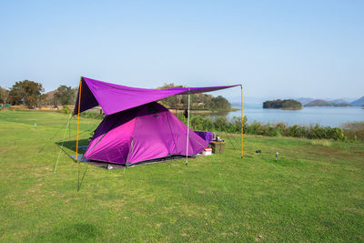 Multi colored umbrella on field against clear sky