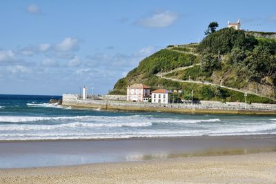Scenic view of beach by sea against sky