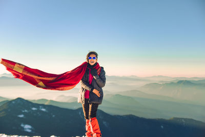 Woman standing on mountain against clear sky