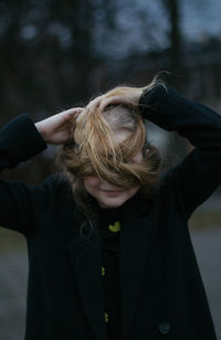 Midsection of woman with arms raised in winter