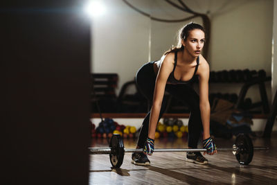 Woman lifting barbells in gym