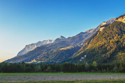 Scenic view of mountains against clear blue sky