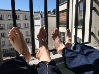 Low section of men relaxing by window