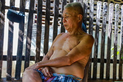 Midsection of shirtless man standing outdoors