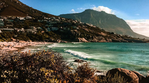 Scenic view of sea by mountains against sky