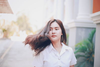 Portrait of beautiful young woman standing outdoors