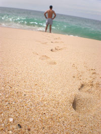 Low section of woman standing on beach