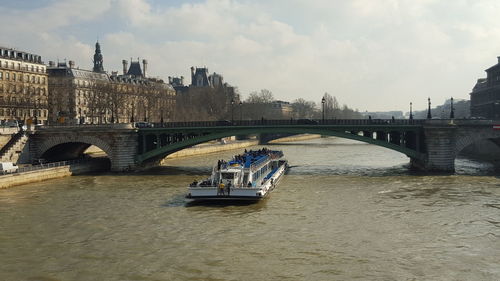 Bridge over river in city against sky