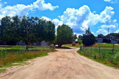 Road amidst trees against sky