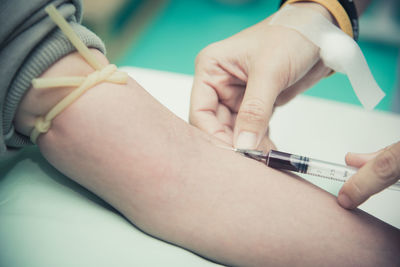 Cropped image of doctor injecting patient