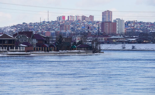 River and buildings against sky