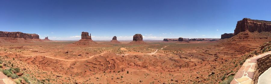 Panoramic view of desert against clear blue sky