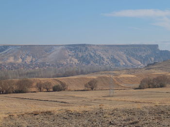 Scenic view of field and mountains against sky