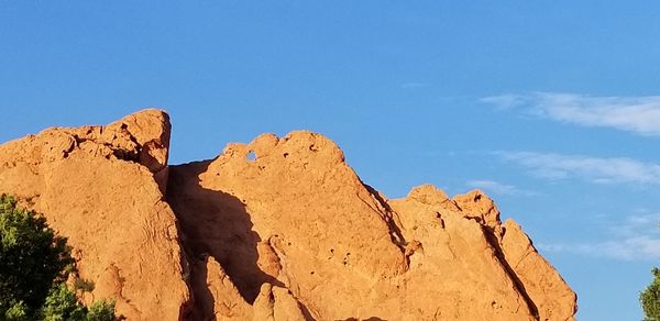 Low angle view of rocks against blue sky