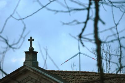 Low angle view of cross on church roof against sky during sunset