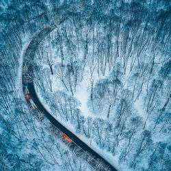High angle view of snow covered railroad tracks by mountain