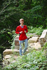 Portrait of teenage boy standing in forest