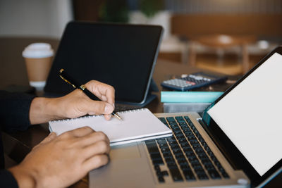 Midsection of woman using laptop on table