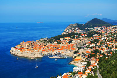 High angle view of city by sea against clear sky