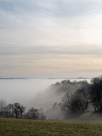 Scenic view of landscape against sky during foggy weather