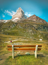 Rear view of man on bench against mountain range