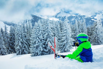 Rear view of man skiing on snow covered landscape