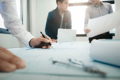 Male architect with coworkers working in office