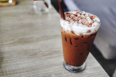 Iced mocha latte with whipped cream on table