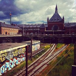 Railroad track against cloudy sky