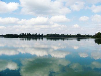 Scenic view of calm lake against cloudy sky