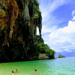 People swimming in sea against sky